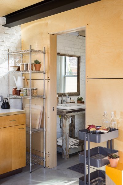Modern home with bath room, concrete floor, wood counter, and vessel sink. View from Kitchen to Bathroom. Baltic Birch wall and Ceiling Panels. Stool by Platform Workshop. www.platformworkshop.com Photo 11 of Blacksmith Shop
