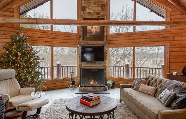 Modern home with living room and gas burning fireplace. This install was done by All Seasons Fireplace in Minnesota: “The homeowners loved the original wood burning fireplace, but their contractor suggested that cutting and carrying wood on a daily basis would get old fast, even with four boys at home to help. They wanted to maintain the large viewing area that the wood burning fireplace allowed, so this Trisore 100H gas fireplace model from European Home was the perfect choice for the room.” Photo of Northwoods Log Cabin