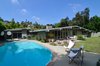 Modern home with outdoor, back yard, large patio, porch, deck, walkways, grass, large pool, swimming pool, pavers patio, porch, deck, planters patio, porch, deck, vertical fence, concrete patio, porch, deck, and wood fence. This home design for the nuclear family of the 50's was perfect in terms of the perfect open plan featuring a central fireplace. with the house originally divided into a sleeping and living wings to allow separation. featuring the living area with open plan and the sleeping quarters set off from the hustle of day-to-day. The central hallway with skylights above allow for light to penetrate into the home, even at the center of the house. This feature was also one of the reasons it became an award winner by the NAHB. Fickett's fenestration was always well thought out, as he typically would use walls of plate glass, skylights above, clerestory windows with their tilt, jalousie windows louvered. Photo 2 of Winning Design | Edward H. Fickett, F.A.I.A | Mid-Century Modern | Encino, CA