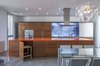 The design and use of color is inspired by dramatic Icelandic landscape to create contrasting stimulating interiors. The orange (volcanic) creates a multi-functional gathering point in the heart of the house. The swimming pool has a blue lagoon color and the cabinets are the colors of glaciers and lava.
To maximize the use of space, the “disappearing” kitchen chairs are easily stored under the island Photo 4 of Dawnsknoll modern home