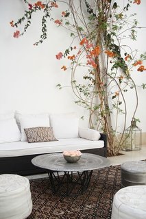 10 Ways to Use Rugs in Your Outdoor Space This Spring - Photo 7 of 10 - Moroccan rugs, leather poufs, and hand hammered silver tables make stark spaces comfortable.