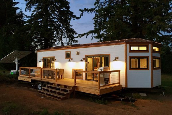 This tiny house on wheels is by Tiny Heirloom. To make the home more eco-friendly, the owner installed a solar panel nearby to generate power.