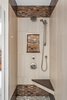 This enlarged shower includes a seat for comfort and two sources of water for an enhanced shower experience. The mixture of tile creates an elegant feel to the space. Two recessed niches provide ample storage for soaps, shampoos, and other bathing essentials. Note the wall tile is the same used on the bathroom floor. Photo 3 of Bathroom Remodel for 1980s Indianapolis Home modern home