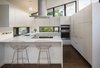 Without increasing the size of the kitchen, we reworked the space to create a family friendly design. This was accomplished by moving the range to the island, adding counter seating and increasing storage with full height cabinetry. Natural lighting in the kitchen was improved by adding low counter height windows. Photo 5 of Mid Century Re-Modern modern home