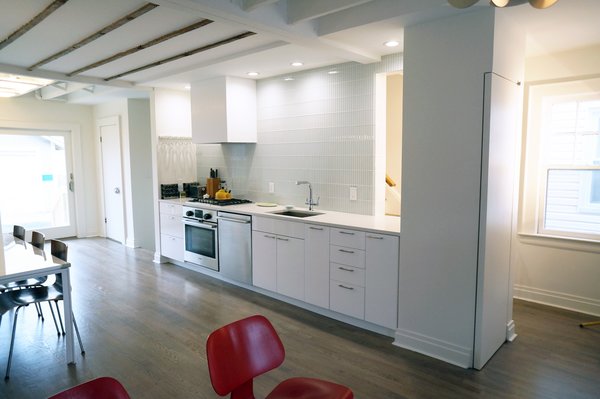 White Box – Kitchen and Living spaces
We were asked by our client to remove two walls in order to open the small space that measures 17’ wide by 31’ long. Two simple ideas drove the design; Light and duality of space. Guided by both we started with what we believe is critical to every project – process of discovery.
The proposed design uses white and dominating color for walls, cabinets and the built in bench. Light colored wood floor will add to the light appearance of space shell. As all dividing walls were removed, perimeter walls were charged with functions; linear kitchen, bench next to dining table, and pantry closet. Avoiding upper cabinets allow the design to be open and make use of the wall as a dynamic element –otherwise a monochromatic space. The newly created functional void connects both ends of space and creates what appears to be a larger and brighter spatial experience. Photo of NY Metro modern home