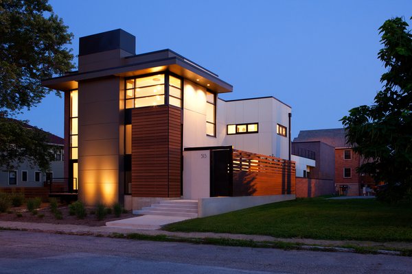 The design provides a layer of privacy for the homeowners, while the solid massing peels away to large expanses of glazing, framing intended view sheds both inward and outward. Along with its verticality, the home pulls key horizontal elements from the established neighborhood rhythm, specifically the eaves and elevated floor lines. Photo of City Cottage modern home