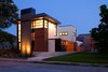 The design provides a layer of privacy for the homeowners, while the solid massing peels away to large expanses of glazing, framing intended view sheds both inward and outward. Along with its verticality, the home pulls key horizontal elements from the established neighborhood rhythm, specifically the eaves and elevated floor lines. Photo of City Cottage modern home