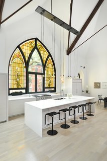 7 Repurposed Churches Around the World - Photo 4 of 8 - This church conversion in Chicago was completed by Linc Thelen Design and Scrafano Architects, and transformed a brick church into a single-family home. Arched stained-glass windows were maintained, and some panels were swapped out for clear glass.