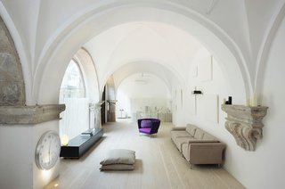 7 Repurposed Churches Around the World - Photo 6 of 8 - In a renovation by Estudio VilaBlanch in a historic neighborhood in Barcelona, cloisters dating from the 1600s were converted into a residence. Hand-carved stone features were left exposed and utilized as shelves, including horizontal belt courses, columns, and imposts for the vaults.