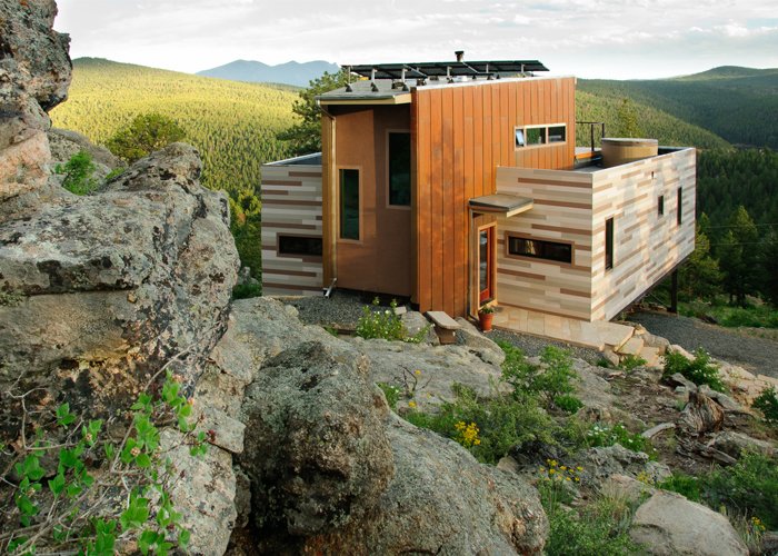 Within the 1500 square feet of this residence, the Denver, Colorado-based architecture firm Tomecek Studio implemented environmentally sensitive strategies including recycled materials, green roofs and photovoltaics. The residence is anchored by an existing rock outcropping and takes full advantage of the distant ridge views to the south. The main floor includes two shipping containers that saddlebag a wedge shaped space. The containers hold the function of bedrooms, bath, office, laundry and kitchen while the center space is used for entry, dining, and living. The upper floor is an open loft with a platform bed that slides on tracks outdoors as a reference to the quintessential camping experience.