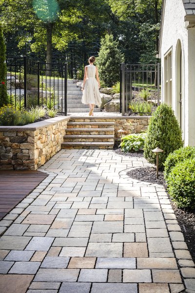 All of the retaining walls around the pool and spa area are footed masonry walls with full profile hand chiseled stone to match the deck’s stone structure and existing stone on the house. The goal behind this stonework was to keep consistent materials throughout the whole project, giving the feeling that everything was built all at the same time. Photo 3 of The Kalimtzis Residence modern home
