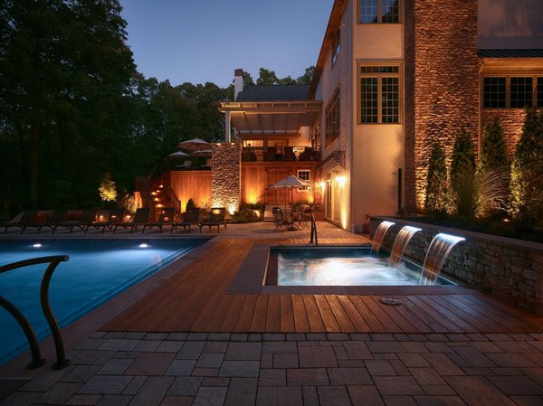 The built-in spa is surrounded by ground-level Cumaru decking, which is the same material used to construct the deck itself. The spa and the three sheer descent water features are completed with LED lighting. Auto covers were installed for the pool and spa to minimize the maintenance when not in use. Photo 10 of The Kalimtzis Residence modern home
