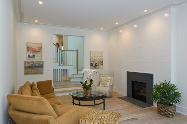 The living room is positioned just off the foyer with two steps down to give it extra interest and to further define the formal space without loosing the open flow of the home. The fireplace surround is accented with shiplap styling and a rich soapstone firebox. The flooring is sustainably harvested white oak grown locally in Connecticut and finished with a zero-VOC finish of beeswax and linseed oil from Rubio Monocoat. Photo 5 of Greenwich Modern Barn modern home