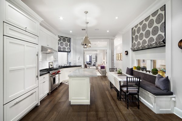 Modern home with kitchen, marble counter, white cabinet, medium hardwood floor, accent lighting, ceiling lighting, refrigerator, wall oven, cooktops, range, dishwasher, drop in sink, and microwave. KITCHEN:
-Custom Sonoma Subway Tile
-Perrin & Rowe faucet with instant hot water
-Vented Hood over chef's Wolf Dual Fuel stove
-SubZero Refrigerator with matching cabinetry front
-Wolf Combination Microwave/Convection Oven
-Custom banquette with additional storage
-Absolute Black polished 2 thick granite countertops
-Oversized island topped with 2 inch thick Carrera marble
-Custom cabinetry all with dovetail soft auto-close drawers
-Bosch Dishwasher
Full size Electrolux Washer and Dryer Photo 9 of Renovated Brownstone Living