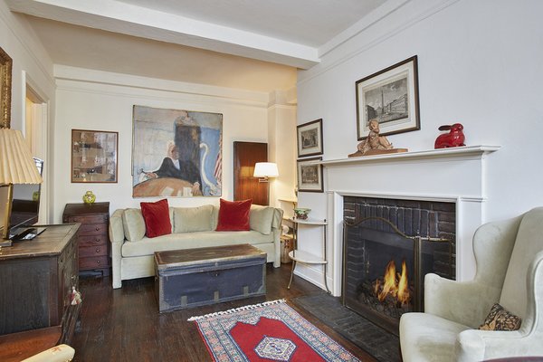 Modern home with living room, sofa, chair, floor lighting, dark hardwood floor, and wood burning fireplace. 10 Mitchell Place, Midtown East - $495,000
Located in a discreet private enclave off 49th Street, 10 Mitchell Place is a charming pre-war building with 24/7 doorman and live-in super. Apartment 9F comprises: sunny living room, 1 bedroom with updated bath, and numerous closets. There are many pre-war details: original mantlepiece, beamed ceilings, and hardwood floors. Sunny open sky views north add to the appeal of this apartment. There is a kitchen would could excel with updating; bike room and laundry. Photo 5 of Five Fabulous NYC Homes For Under $500K
