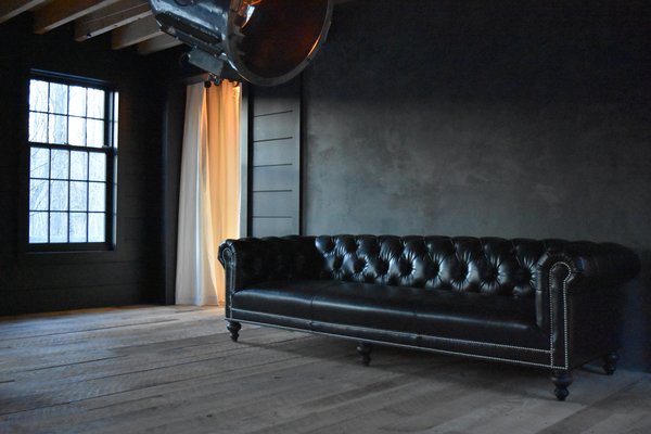 The Photo was taken in the evening for a quiet and subtle effect. The purity of the space is an escape from the high drama of the rest of the home. The only things in this living room are the black 9' long chesterfield sofa from "Of Iron & Oak", the huge 32" diameter vintage search light from the Suez Canal, the piano and a fireplace opposite of the chesterfield. Photo 6 of The Lodge modern home