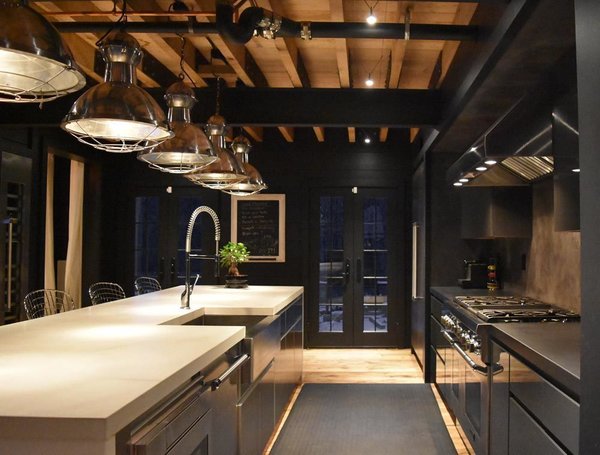Designed to cook. Galley Kitchen. Stainless Steel Cabinets inside and out shown on the left, and high gloss gray cabinets with stainless interiors shown on the right. All cast concrete counter tops. Vintage nautical lights sourced abroad and originally from somewhere interesting I'm sure... Thermador Applaiances, wide plank oak flooring, exposed oak and steel frame. Photo 8 of The Lodge modern home