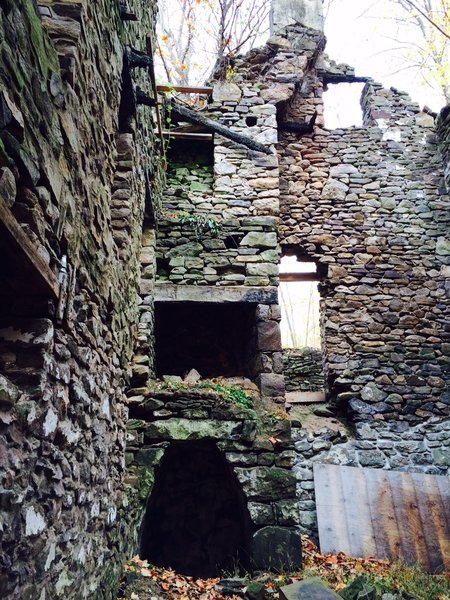The layers of life can be seen here. A large root cellar on the lower walk out level, with a walk in fireplace on the second/main story and a smaller corner fireplace on the top/3rd floor bedroom area. The stairs would be where the the photographer was standing here. Plus if you look closely, you can see a round hole in the fireplace wall on the third floor level. This hole was an exhaust inlet for a wood stove, which was a later addition to the original homestead. When the invention of the wood stove took off, heating had never been more convenient. This 1,600 sqft homestead had at least four wood stoves based on the various stove exhaust inlets into the masonry chimneys. It would have been toasty warm. Photo 5 of Screaming for Life - circa 1680's Homestead, Bucks County Stone House modern home