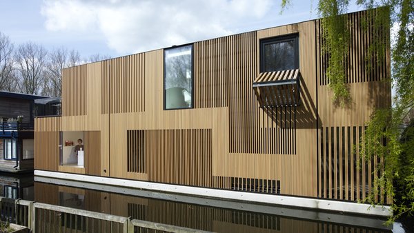10 Modern Floating Homes That Offer an Aquatic Lifestyle - Photo 7 of 10 - "Water Villa" features a sunken floor below the water and an atrium at the center of the house that connects the children's rooms in the basement with the living and dining rooms on the ground floor. 