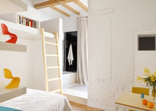 This Barcelona apartment features raised platforms throughout, creating unexpected and efficient living and storage spaces. 