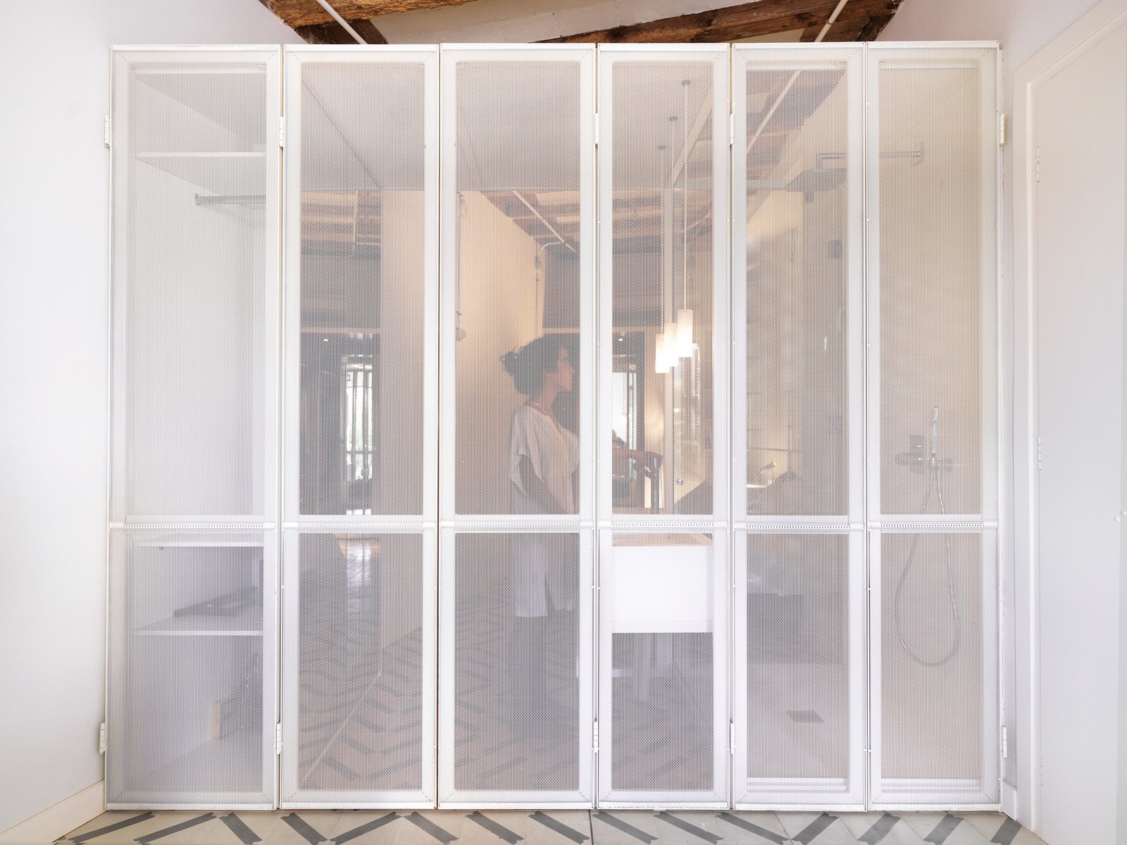 The Lightox, A perforated metal screen separates the living space from the private zone, allowing all natural ight to enter