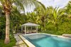 Modern home with outdoor, side yard, garden, back yard, shrubs, trees, grass, hardscapes, walkways, small pool, gardens, swimming pool, plunge pool, lap pool, standard construction pool, and concrete patio, porch, deck. Outdoor seating with cover was designed to protect from the harsh summer sun of the Florida Keys as well as create an extra space for privacy and relaxation. Lush tropical planting was designed around the property for privacy and shade with the clean lines of the pool extending to the poured-in-place concrete pavers. Photo 8 of Waterfront Sanctuary