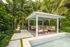 Modern home with outdoor, back yard, trees, side yard, garden, shrubs, grass, hardscapes, walkways, lap pool, swimming pool, standard construction pool, gardens, plunge pool, concrete patio, porch, deck, and small pool. Outdoor seating with cover was designed to protect from the harsh summer sun of the Florida Keys as well as create an extra space for privacy and relaxation. Lush tropical planting was designed around the property for privacy and shade with the clean lines of the pool extending to the poured-in-place concrete pavers. Photo 7 of Waterfront Sanctuary