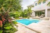 Modern home with outdoor, trees, front yard, hardscapes, shrubs, walkways, small pool, standard construction pool, swimming pool, pavers patio, porch, deck, large patio, porch, deck, landscape lighting, and garden. A secondary step-up was created to add height to make up the grade. The water fountain was added to the pool with a ledge directly underneath to sit on so the water could spill onto the home owners or it could function as a visual feature while the sound of the running water could be enjoyed whether or not they were relaxing in or by the pool. The original property had the swimming pool at the front of the house and the decision was made that it would remain in the same place so the clients could get the effect of walking over water when they enter their home. Photo 3 of Key West Modern