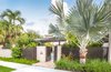 Modern home with outdoor, shrubs, front yard, trees, grass, hardscapes, small pool, walkways, swimming pool, standard construction pool, large patio, porch, deck, pavers patio, porch, deck, landscape lighting, metal fence, and garden. Privacy was an important factor for the clients but the fencing had to be kept under a certain height due to regulations in Old Town Key West. Powder-Coated aluminum was used so the visual weight of the fence didn't feel too heavy. Dense tropical planting was strategically placed to help maintain privacy. A modern postbox and street numbers were used in keeping with the style of the property. Photo of Key West Modern
