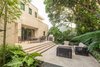 Modern home with outdoor, hardscapes, garden, back yard, walkways, gardens, shrubs, trees, pavers patio, porch, deck, large patio, porch, deck, and landscape lighting. The hardscape of the patio was designed to match the architecture. Clean lines and a modern feel were an important factor for the clients. Indoor/outdoor living is a must for this outdoor dining area. Accordion doors allow for the refreshing winter breeze to blow throw the house and allow for an easy transition between the front of the property and the back. Photo 16 of Key West Modern