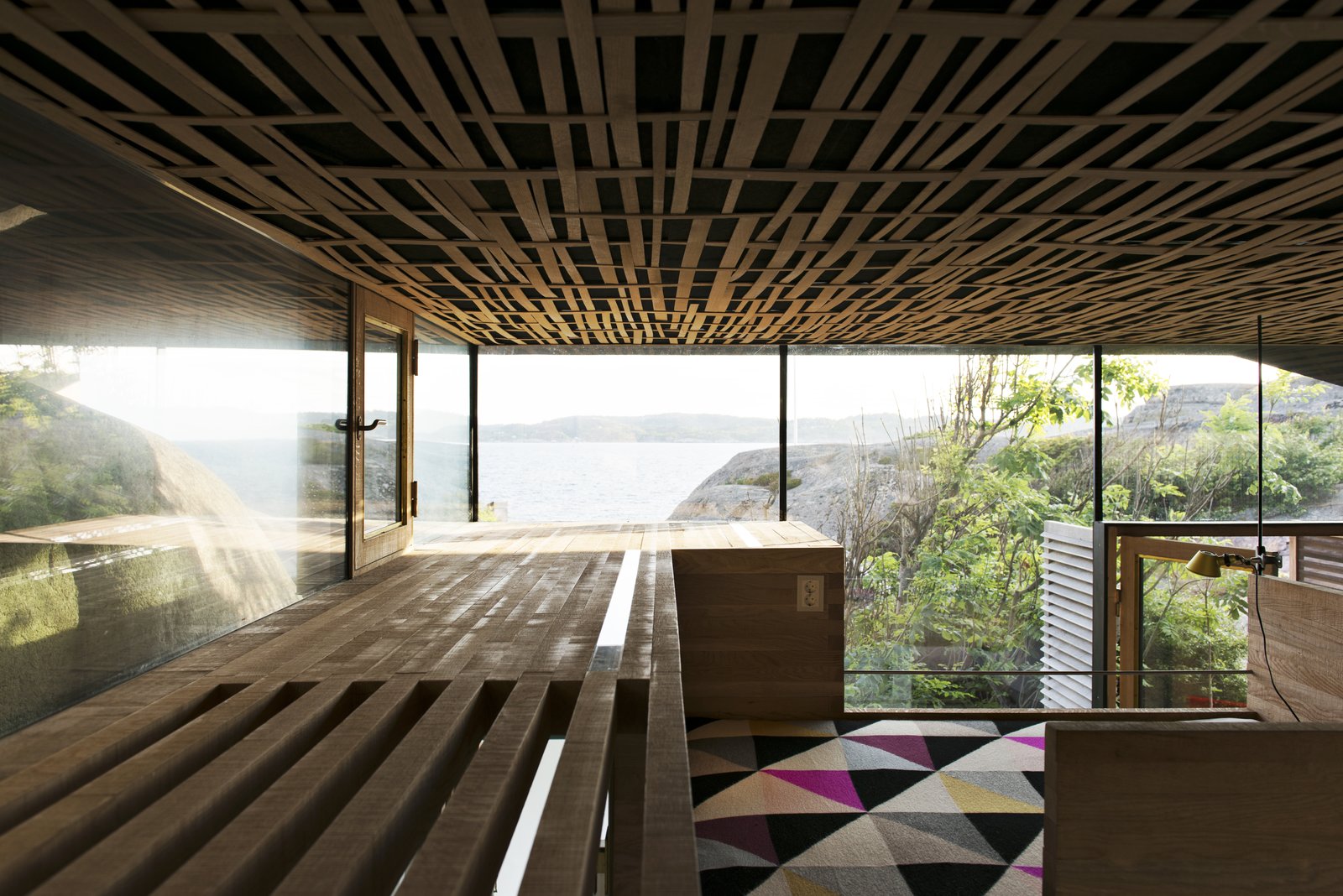 The interior walls are solid 50/50mm oak layered with a natural sawn texture, while the acoustic ceiling is covered with woven oak strips.