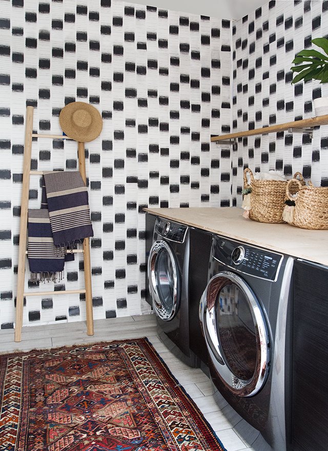 The laundry room features custom wallpaper designed by Samuel.