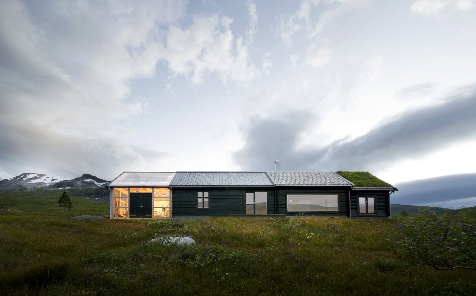 "In the western facade of the building the individual characters of the different units are most obvious, while in the eastern facade (seen here) their coherence and the cabin as a whole is more prominent," write the architects.