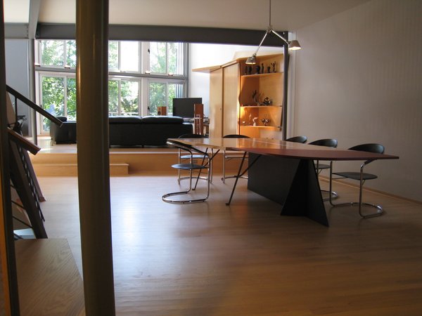 looking S from entry: “grasshopper” dining room table seats 12. mdf board w/plastic laminate, oak plywood, aluminum angle & bar, skinny steel legs like a grasshopper’s. all of the major interior materials are incorporated into this piece. FYI, most of the interior furnishings were built on site. overhead lighting by artemeide. living room media center beyond. Photo 7 of metalHOUSE(2) modern home