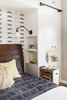Optimum functionality was important for the bedside built-ins. Clients each a pull out nightstand with adjustable shelves and wood top, open shelves facing the bedside, and articulating sconce with it's own switch. The overall aesthetic is warm, clean and minimal, with white cabinets, stained European white oak floors, and matte black hardware. An accent wall of Cavern Home wallpaper adds interest and ties the finishes of the room together. Photo 7 of Barton Hills Bedroom modern home
