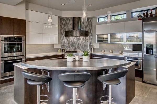 Modern home with front yard, side yard, trees, flowers, walkways, shrubs, grass, large patio, porch, deck, stone patio, porch, deck, landscape lighting, sectional, ceiling lighting, concrete floor, kitchen, and gas burning fireplace. Entertainers kitchen with Caesar-stone & Pewter counters, one of a kind Pewter cook top hood, under counter lighting, stainless steel appliances and artistic back splash that highlights the gas cook top!
See more: www.DowntownKirklandModern.com Photo 4 of Downtown Kirkland Modern
