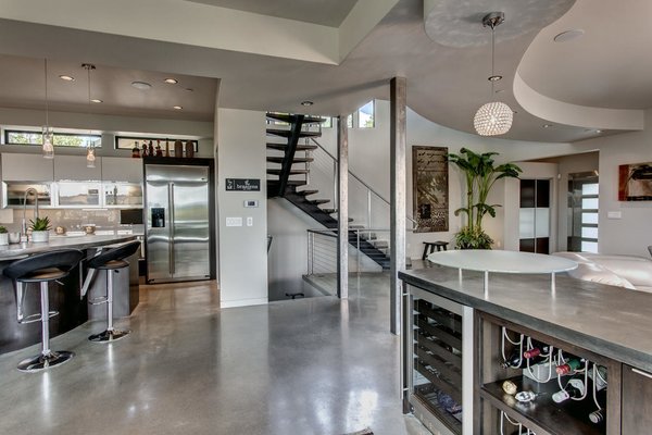 Modern home with trees, side yard, shrubs, grass, front yard, flowers, walkways, large patio, porch, deck, stone patio, porch, deck, landscape lighting, sectional, ceiling lighting, concrete floor, refrigerator, gas burning fireplace, microwave, dishwasher, range, range hood, and living room. Great room perfectly blends the kitchen, dinning room, family room and outdoor spaces into a spacious living area for the way we live today!
See more: www.DowntownKirklandModern.com Photo 5 of Downtown Kirkland Modern