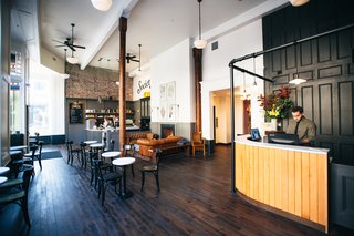A Chic Portland Hotel Offers Lodging As Affordable as $35 a Night - Photo 3 of 10 - The lobby of the hotel contains a cafe and lounge space that's complete with a fireplace. The cozy atmosphere provides an ideal location from which to look out onto the city and enjoy a beverage with fellow travelers.