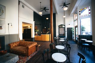 A Chic Portland Hotel Offers Lodging As Affordable as $35 a Night - Photo 4 of 10 - In a nod to the past, the original doors have been re-purposed and now provide decorative paneling behind the reception desk.
