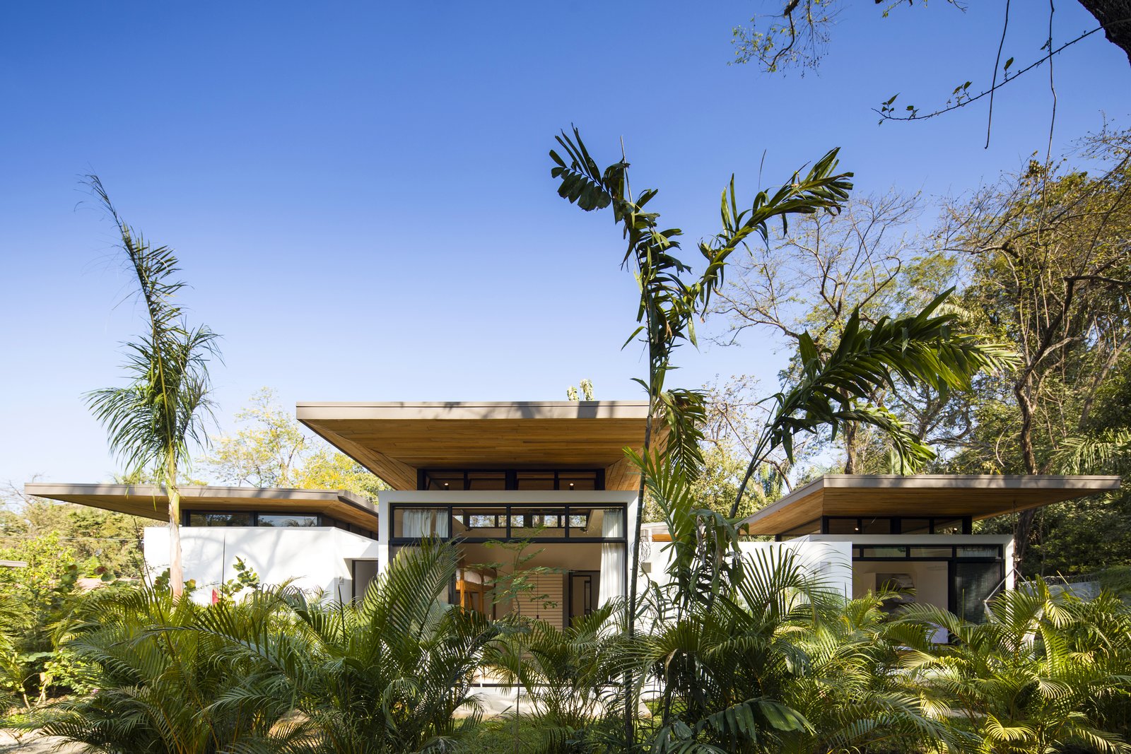 Each villa is composed of a series of spaces, varying from two to three bedrooms, and offers different views out to the ocean. Overlapping timber roofs made from recycled teak planks and built by local craftsman provide shade from the powerful sun.