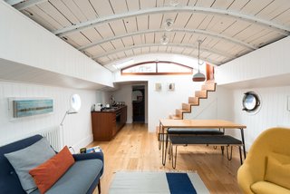 Londoners Can Live in This Scandinavian-Inspired, Converted Barge For $424K - Photo 2 of 9 - An uplifting color palette and restored midcentury furnishings, such as the 60s Greaves and Thomas Egg chair, fill the living space. 