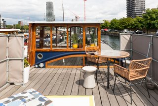 Londoners Can Live in This Scandinavian-Inspired, Converted Barge For $424K - Photo 9 of 9 - A round concrete stool, table and chairs, custom cushions, and outdoor rug create the perfect terrace setting to look out to the city beyond. 
