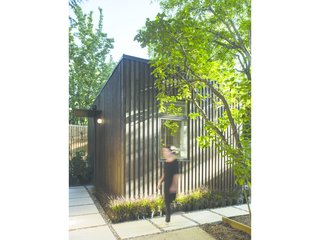 A Modern Micro-House in Portland Clad in Local Fir - Photo 8 of 8 - Light and shadow play on the textured facade. Greenery frames the simple, geometric form of the house. 