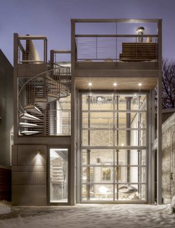 A Steel-and-Glass Addition With a Giant Hangar Door Maximizes Indoor/Outdoor Living - Photo 1 of 9 - Here, the steel-and-glass addition is closed, protected from the winter cold. 