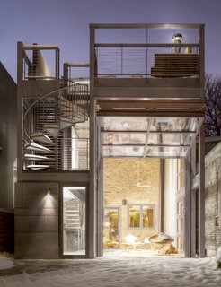 A Steel-and-Glass Addition With a Giant Hangar Door Maximizes Indoor/Outdoor Living - Photo 2 of 9 - With the hangar door open, you can see the historic brick wall of the original house beyond. 