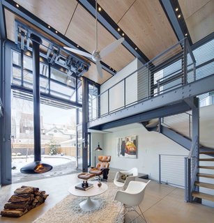 A Steel-and-Glass Addition With a Giant Hangar Door Maximizes Indoor/Outdoor Living - Photo 6 of 9 - The polished concrete floor resembles the limestone pavers on the exterior, enhancing the continuous connection between inside and outside.