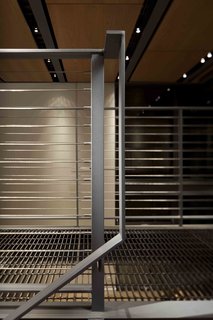 A Steel-and-Glass Addition With a Giant Hangar Door Maximizes Indoor/Outdoor Living - Photo 8 of 9 - Simple, modern details frame the catwalks and stairways that connect the spaces vertically and laterally. A grated walk allows light to penetrate further into the space. 