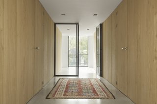 A Converted Warehouse in Amsterdam Boasts Soothing Interiors of Concrete and Wood - Photo 5 of 9 - Rough oak cabinetry frames the corridor that leads between the communal areas and the private beds and baths. 