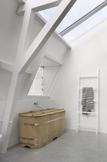 A Converted Warehouse in Amsterdam Boasts Soothing Interiors of Concrete and Wood - Photo 8 of 9 - A traditional Japanese-style bathtub, custom-ordered through Bartok Design, sits elegantly in one of the baths.
