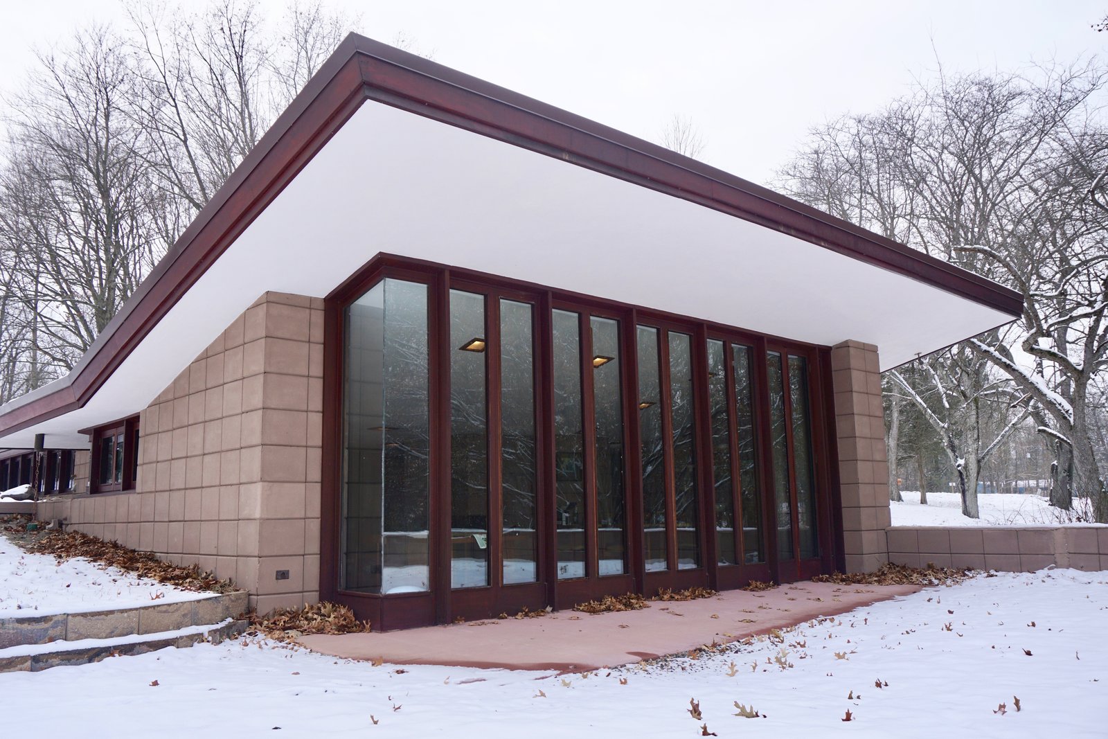 The cantilevered roofs and trim have been carefully painted and restored. Large windows blend the exterior terrace with the inside living space.